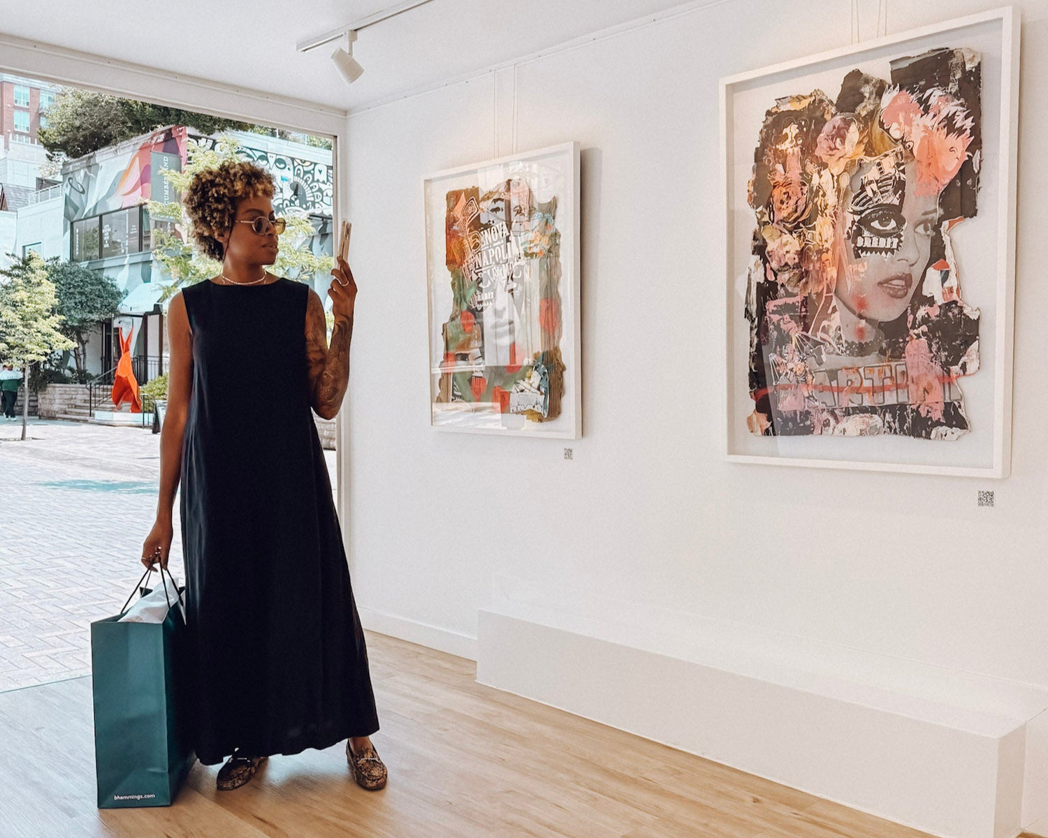 Woman walking through an art gallery with modern abstract paintings on the walls.
