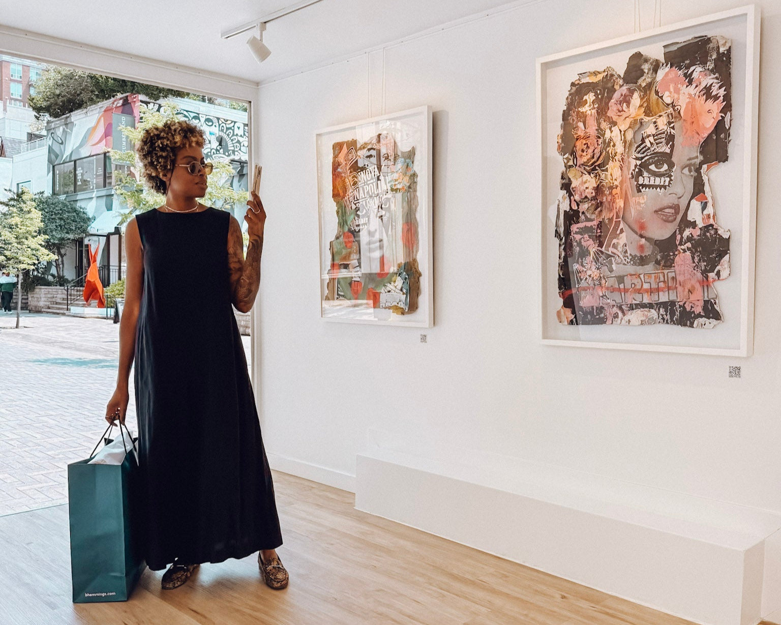Woman walking through an art gallery with modern abstract paintings on the walls.